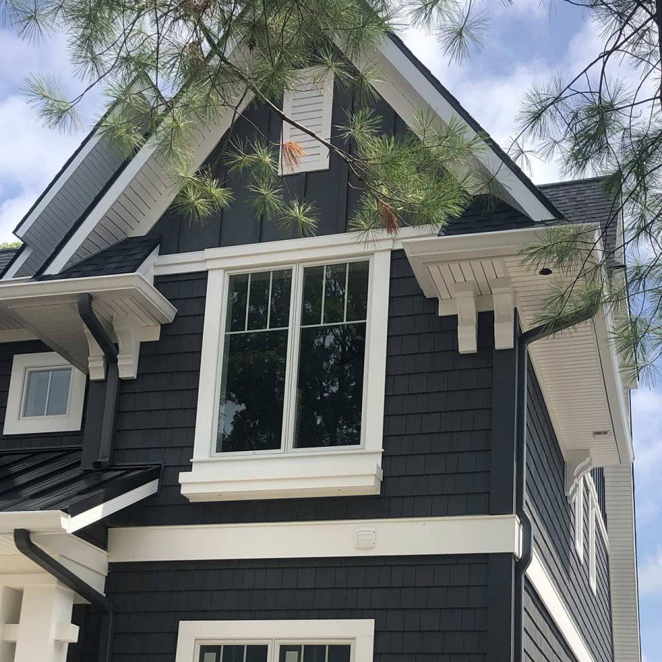 Front of a dark gray house with a custom gutter system installed