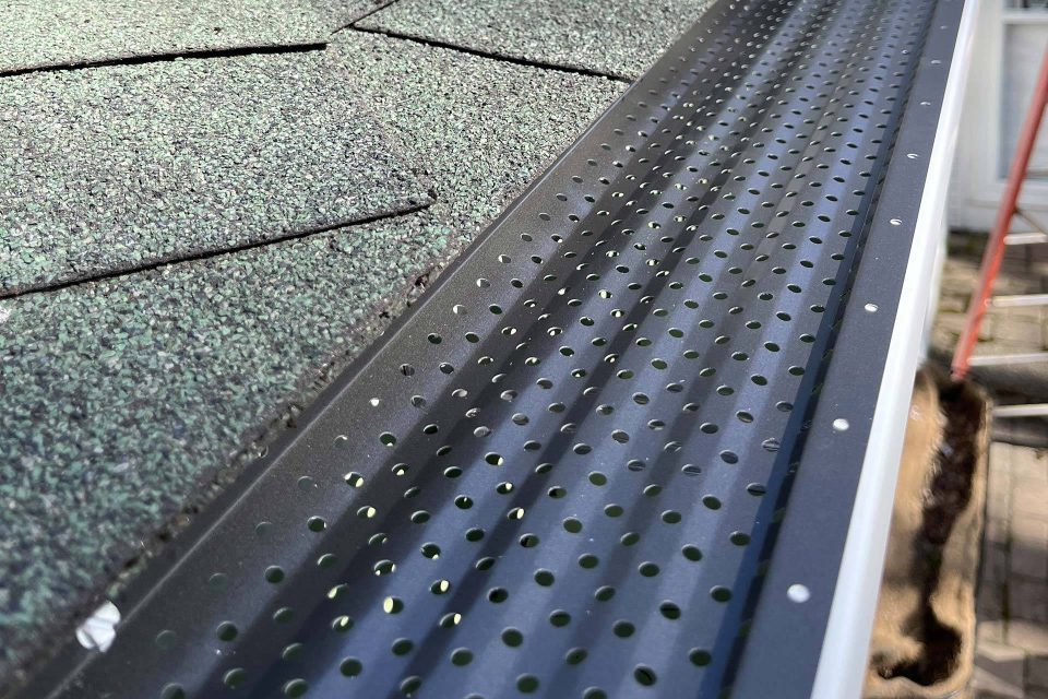 Close-up of new gutter guard installation on a residential roof and gutter system